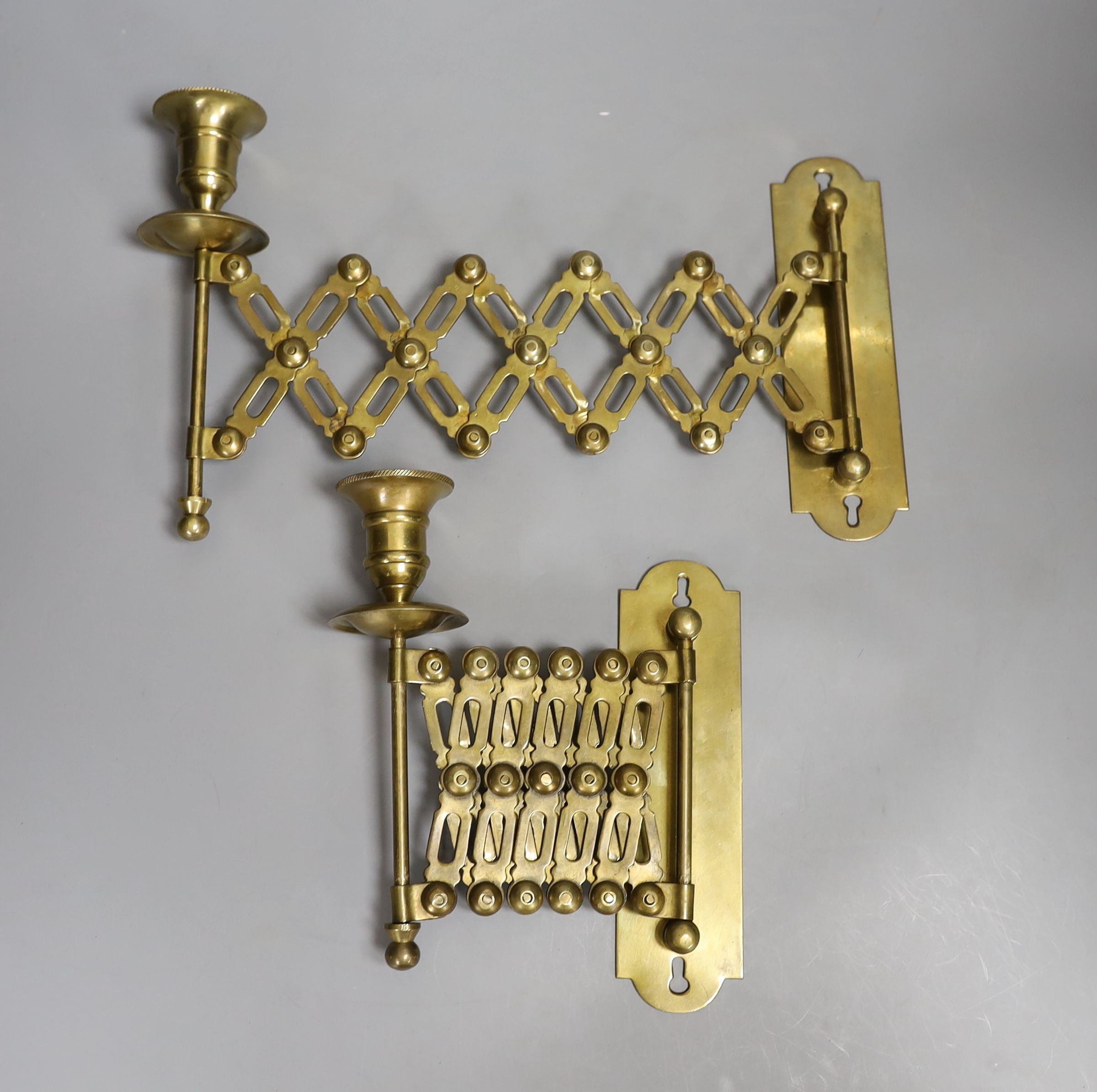 A pair of brass concertina action candlesticks